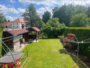 un jardín con una casa en el fondo y un edificio en Ubytování u Novotných, en Vyšší Brod