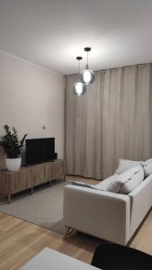 sala de estar con sofá blanco y TV en Casa Vacanze Como, en Como