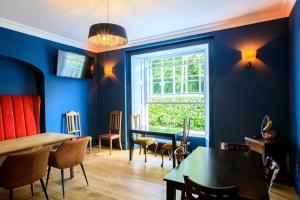 a dining room with blue walls and a table and chairs at Coach House at Picton - Restaurant and bar on site in St Clears