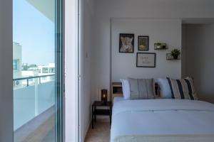1 dormitorio con 1 cama y balcón en Chloris 3- Bedroom Apartment W/Pool in Larnaca, en Lárnaca