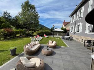 un patio con un montón de sillas y mesas en La maison des douceurs, en Bussang