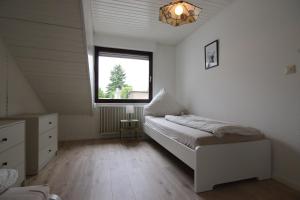 a small bedroom with a bed and a window at Monteurwohnung Saarlouis, Ferienhaus, WLAN, Parkplatz in Saarlouis