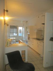 uma cozinha com uma cadeira preta num quarto em Plateau de 47 m2 Victoire - Marché des Douves em Bordeaux