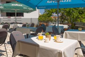 a group of tables and chairs with drinks on them at Pansion Pirat in Petrcane