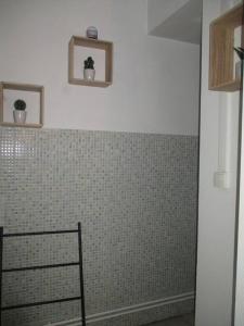 uma casa de banho com uma parede em azulejo e uma cadeira. em Plateau de 47 m2 Victoire - Marché des Douves em Bordeaux