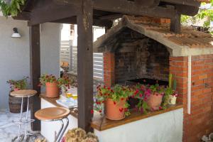 een bakstenen oven met potplanten op een patio bij Pansion Pirat in Petrcane