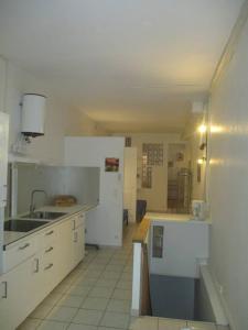 uma cozinha com armários brancos, um lavatório e um frigorífico em Plateau de 47 m2 Victoire - Marché des Douves em Bordeaux