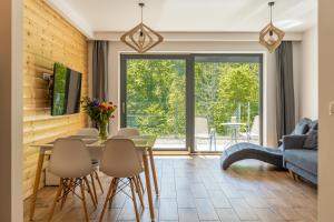 シュチルクにあるApartament Solisko z widokiem na trasę narciarską - Dream Apartのリビングルーム(テーブル、椅子、青いソファ付)