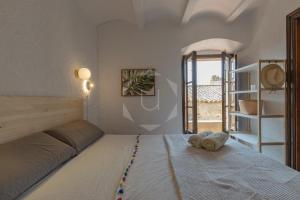 een slaapkamer met een bed met handdoeken erop bij PALS - Maison médiévale tout confort in Pals