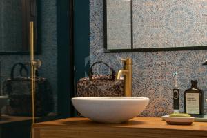 a bathroom with a sink and a bottle of wine at PALS - Maison médiévale tout confort in Pals