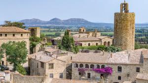 a view of a village with a tower and buildings at PALS - Maison médiévale tout confort in Pals
