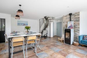 een woonkamer met een tafel en stoelen en een open haard bij Instants de repos et de detente a Sarzeau in Sarzeau