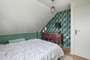 een slaapkamer met een bed en een groene muur bij Instants de repos et de detente a Sarzeau in Sarzeau