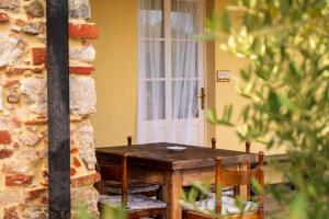 uma mesa e cadeiras num alpendre com uma janela em Corte Volpe Home em Lucca
