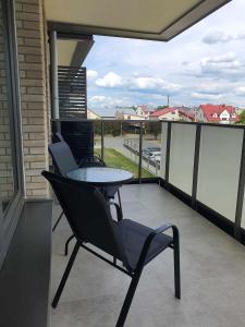 patio ze stołem i krzesłami na balkonie w obiekcie Apartament Augustów ,Arnikowa w mieście Augustów