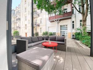 un patio con sofá y mesa roja en Designer Loft-Ferienwohnung im Zentrum mit Waschmaschine und Privatterrasse, en Leipzig