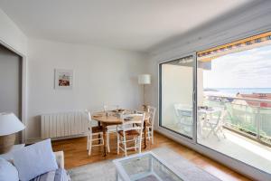 a living room with a table and a large window at Appartement pour 4 avec vue mer à Pléneuf in Le Val-André