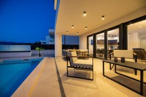 a house with a swimming pool and a dining area at Villa Aria in Klimno