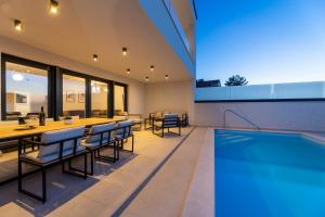 an indoor dining area with a pool and dining table and chairs at Villa Aria in Klimno