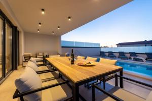 a dining room with a table and chairs and a pool at Villa Aria in Klimno
