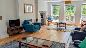 a living room with a blue couch and a table at Bryn Capel, Gwynfe in Gwynfe