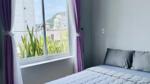 a bedroom with a bed and a window with a view at Simi Homestay in Vung Tau
