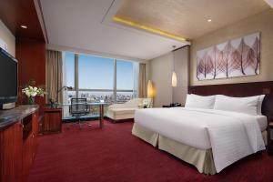 a hotel room with a large bed and a desk at Beijing Marriott Hotel Northeast in Beijing