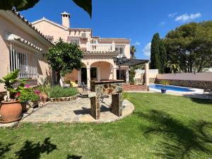 a large house with a lawn and a pool at Bonito-Sol in Sitio de Calahonda