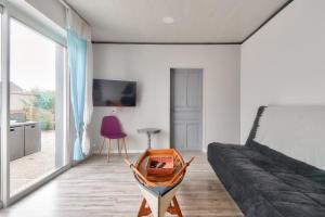 a living room with a bed and a table at Maison pour 7 à 100m de la plage - Jardin in La Barre-de-Monts