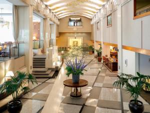 um corredor com vasos de plantas num edifício em Premier Hotel -Tsubaki- Sapporo em Sapporo