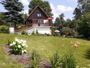 a house on a hill with a yard with flowers at Chata Bohouš in Petrovice