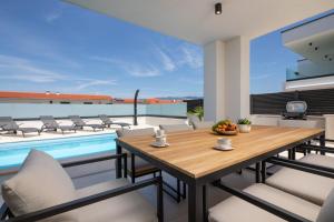 una sala da pranzo con tavolo, sedie e piscina di Villa Aria a Klimno