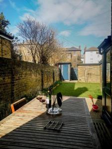 a table with two glasses of wine on a wooden deck at Cliff Cottage with private garden - Broadstairs in Kent