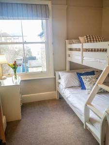 a bedroom with two bunk beds and a window at Cliff Cottage with private garden - Broadstairs in Kent