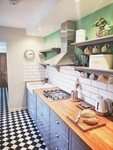 a kitchen with blue cabinets and a counter top at Cliff Cottage with private garden - Broadstairs in Kent