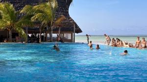 grupa osób w basenie na plaży w obiekcie NDAME Paje Hotel w mieście Paje