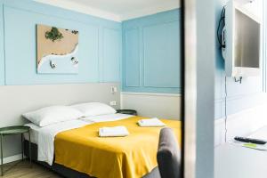 a bedroom with a bed with a yellow blanket at Hotel Plaza in Pag