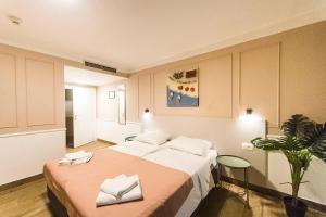 a bedroom with two beds and a plant in it at Hotel Plaza in Pag