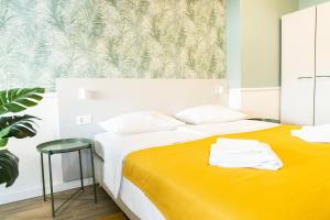a bedroom with two beds and a yellow blanket at Hotel Plaza in Pag