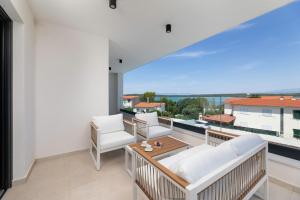 un balcone con mobili bianchi e una grande finestra di Villa Aria a Klimno