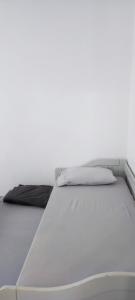 a bed in a room with a white wall at Maison de la plage in Valras-Plage