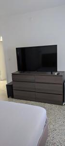a flat screen tv sitting on top of a dresser at Maison de la plage in Valras-Plage
