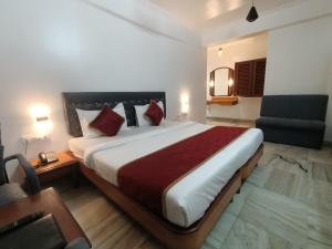 a hotel room with a large bed and a chair at Raja Hotel in Kalyan