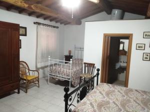 um quarto com uma cama e uma cadeira em Casetta in campagna. Bilocale con veranda em Scansano