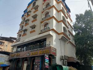 a tall white building with a sign on it at Raja Hotel in Kalyan