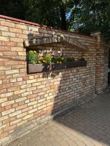 een stenen muur met een raam met bloemen erin bij ApartmentTallinas70B in Rīga