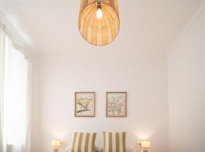 Habitación con 2 sillas y luz colgante en SibsSanlucar Duquesa Loft Coqueto Ideal Parejas, en Sanlúcar de Barrameda