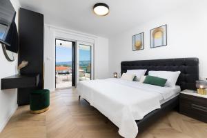 una camera bianca con un grande letto e un balcone di Villa Aria a Klimno Altre 42 foto