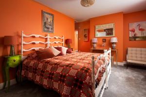 1 dormitorio con 1 cama con pared de color naranja en Fell End, en Brampton