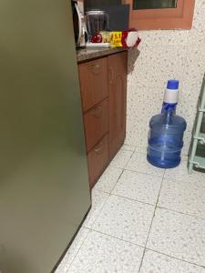 ein blaues Fass, das in einer Küche auf dem Boden liegt in der Unterkunft Najm home in Ajman 